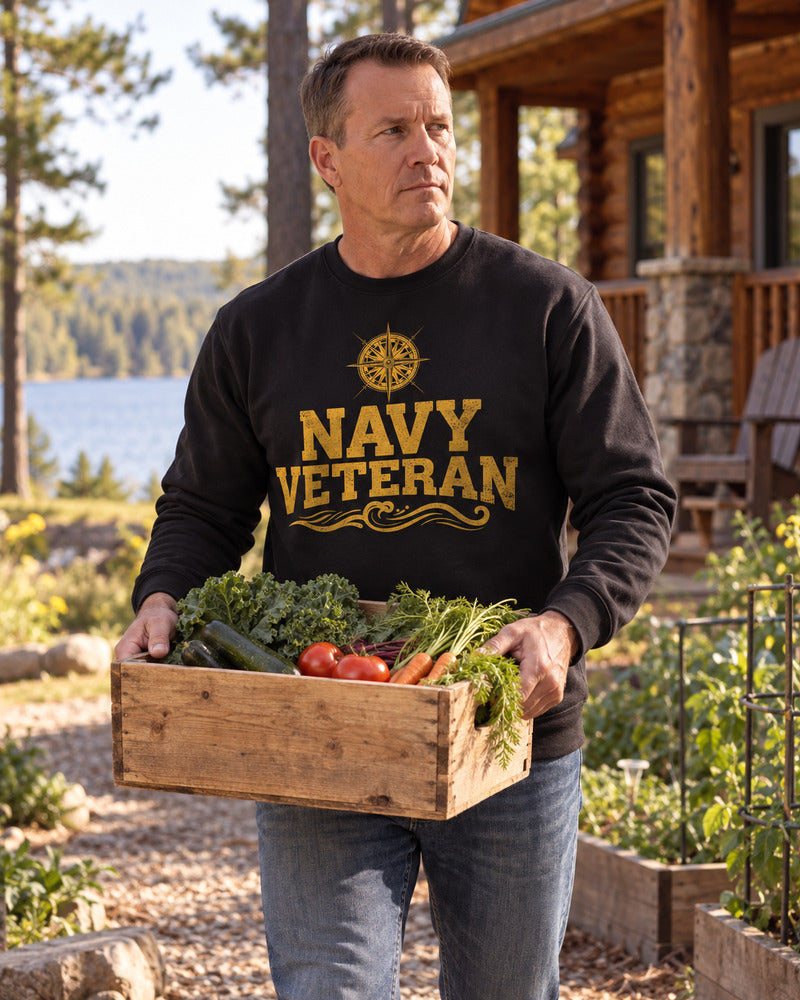 A man carrying garden produce in a Navy sweatshirt.
