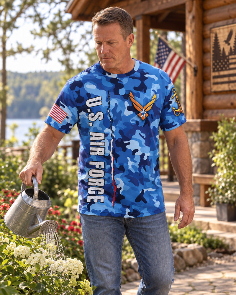 A man watering plants in an Air Force T-shirt.