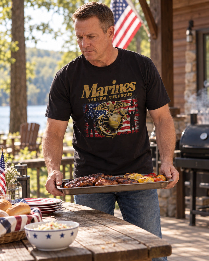 A man setting a tray on a picnic table in a Marine Corps T-shirt.
