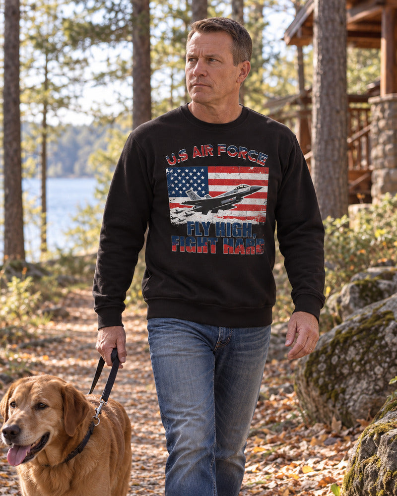A man walking a dog in an Air Force sweatshirt.